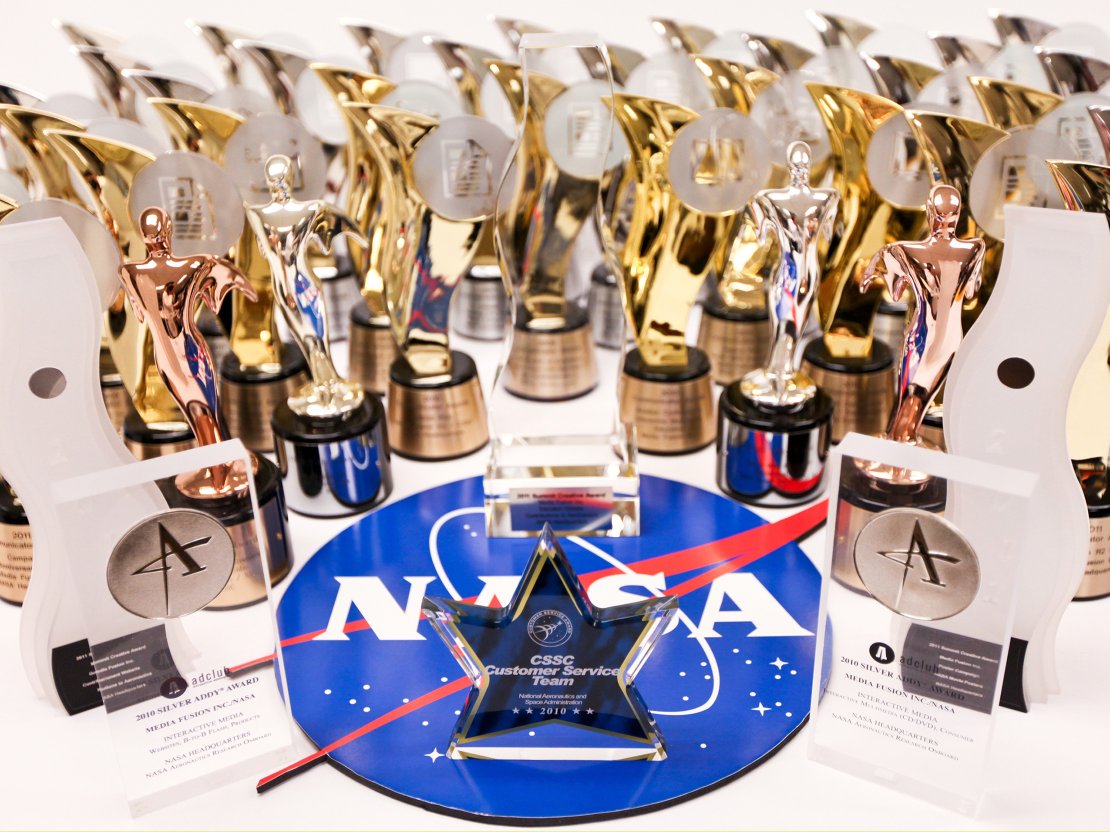 A collection of Media Fusion's awards from the American Advertisting Federation, the Communicator Awards, and NASA